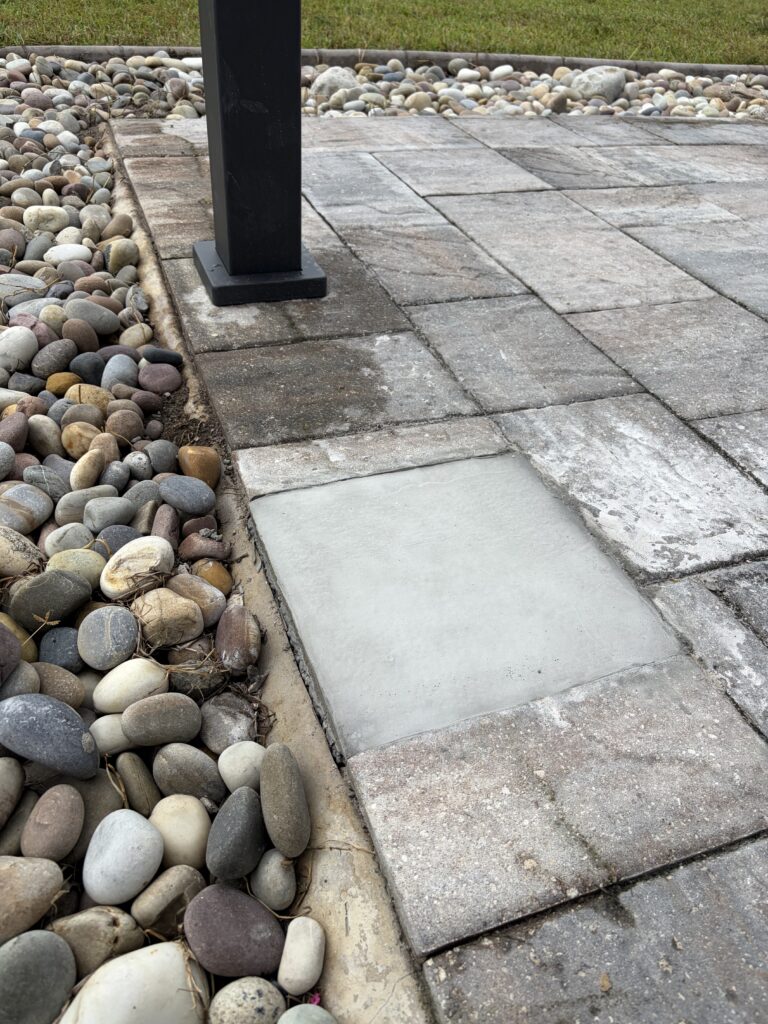 Concrete footing supporting a pergola post on a paver patio in Oviedo